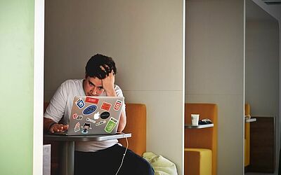 Zeitmanagement im Beruf: Mann vor seinem Laptop